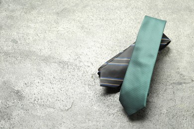 Photo of Two neckties on grey textured background, top view. Space for text