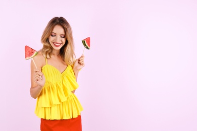 Pretty young woman with juicy watermelon on color background