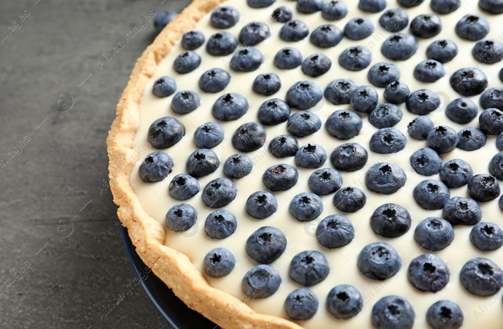 Photo of Tasty cake with blueberry on gray table