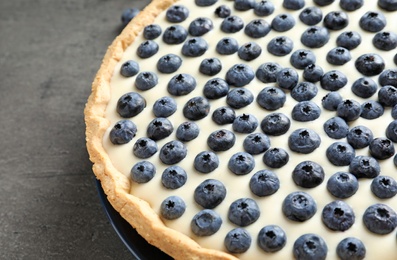 Tasty cake with blueberry on gray table