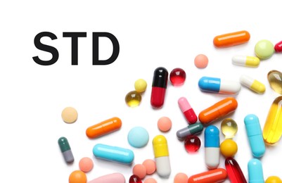 Different pills and abbreviation STD on white background, top view