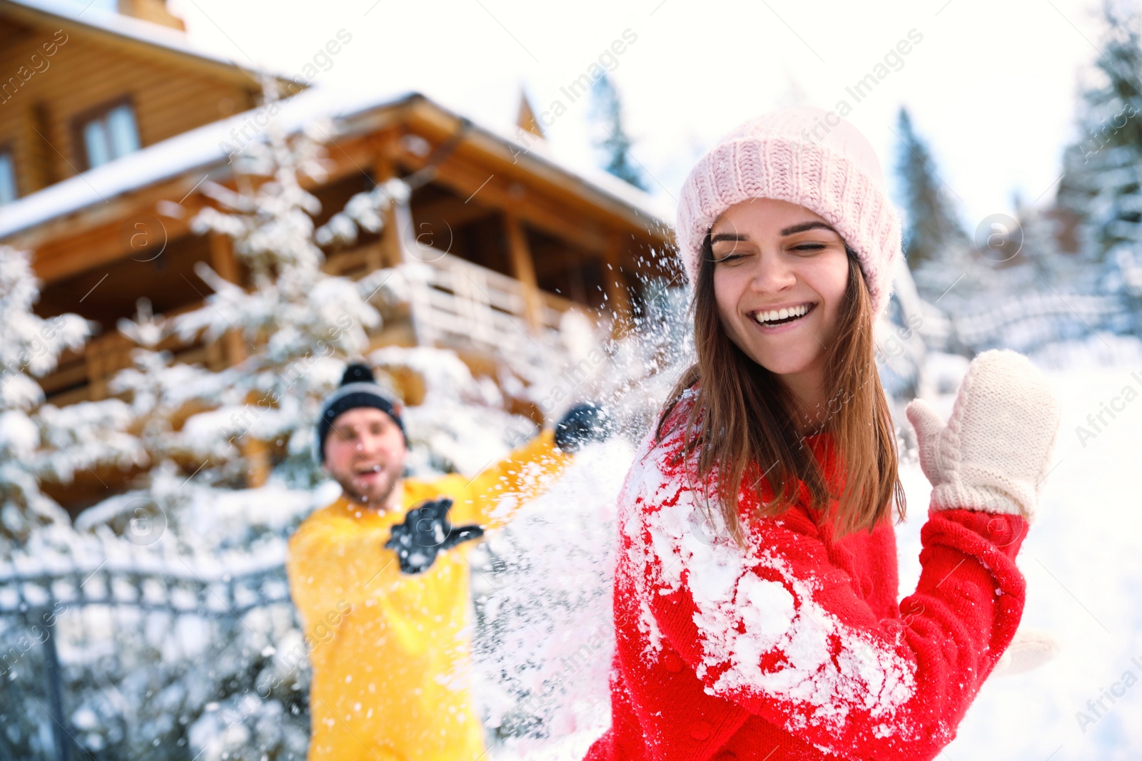 Photo of Happy couple playing snowballs outdoors. Winter vacation