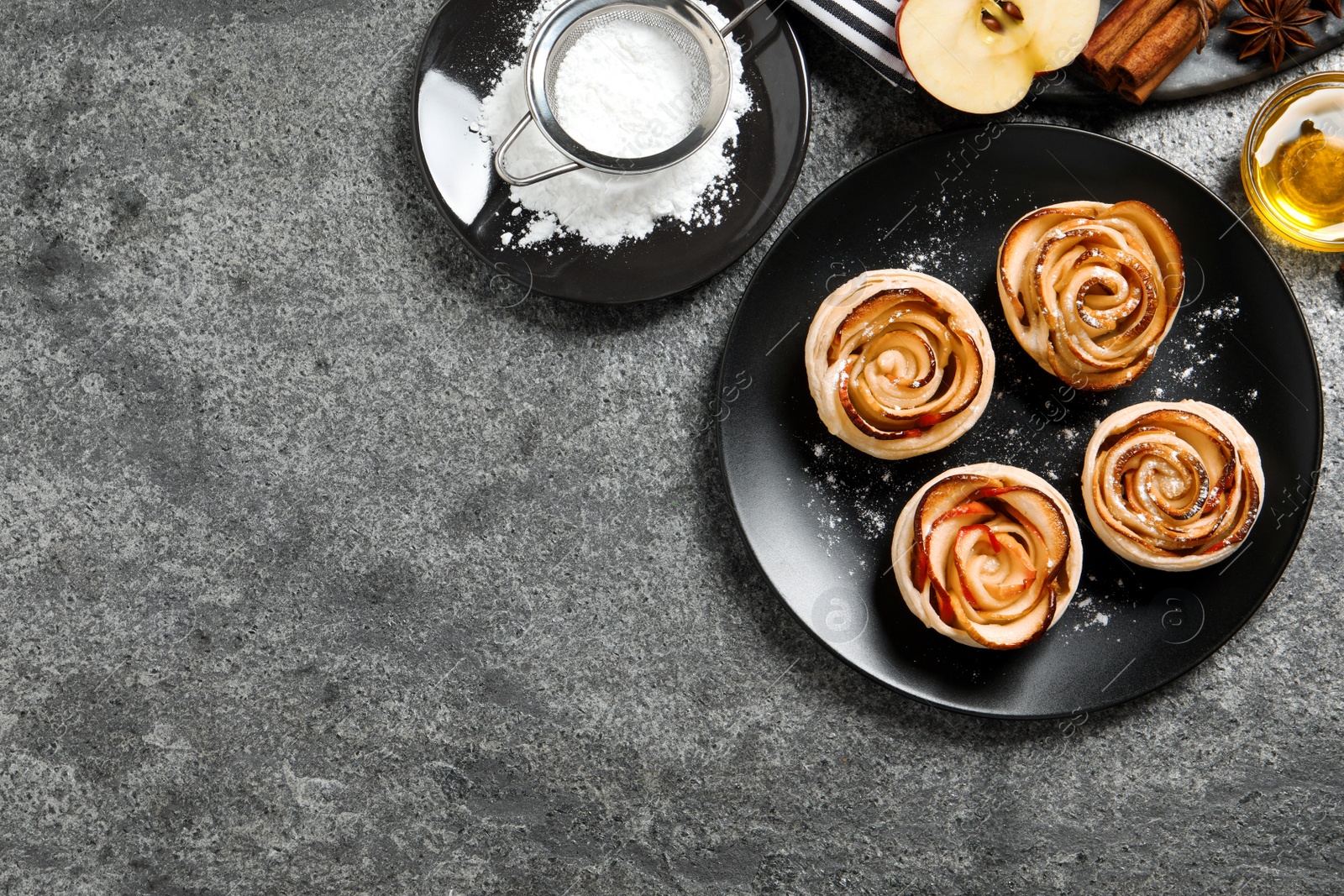 Photo of Freshly baked apple roses on grey table, flat lay. Space for text