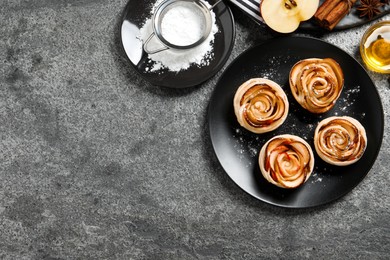 Freshly baked apple roses on grey table, flat lay. Space for text