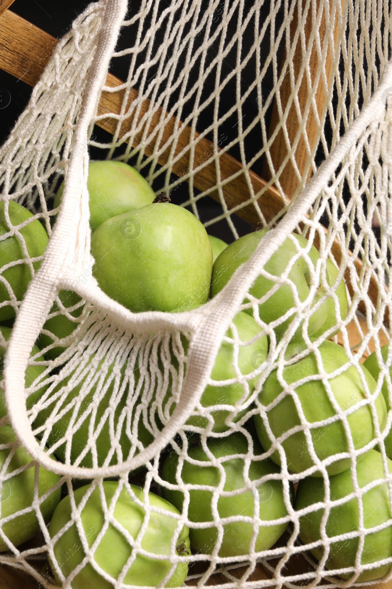 Photo of Fresh green apples in net bag, closeup