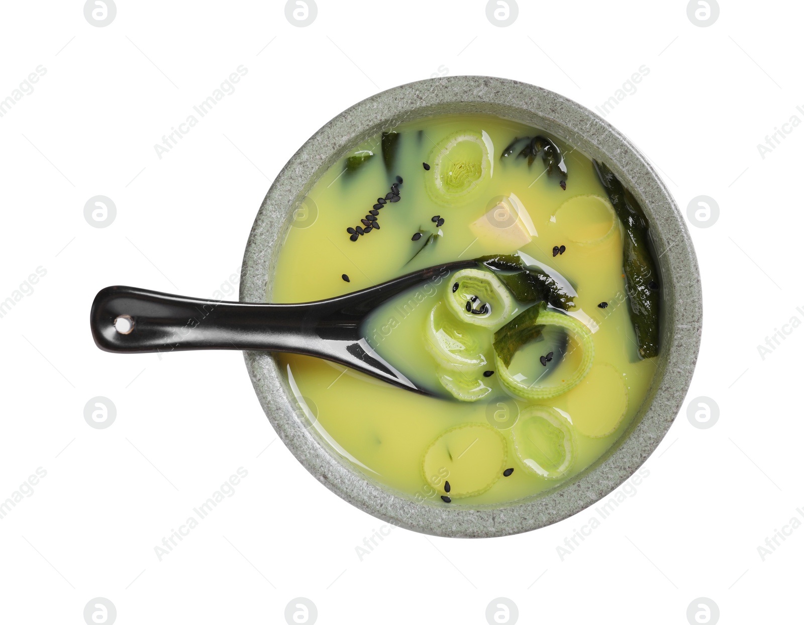 Photo of Bowl of delicious miso soup with tofu and spoon isolated on white, top view