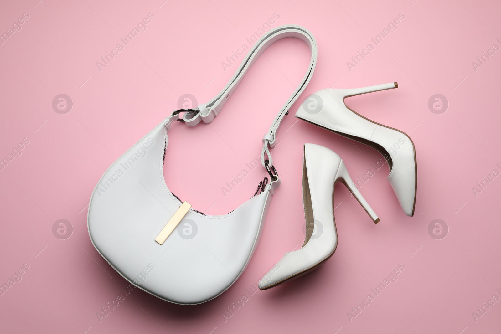 Photo of Stylish woman's bag and shoes on pink background, flat lay