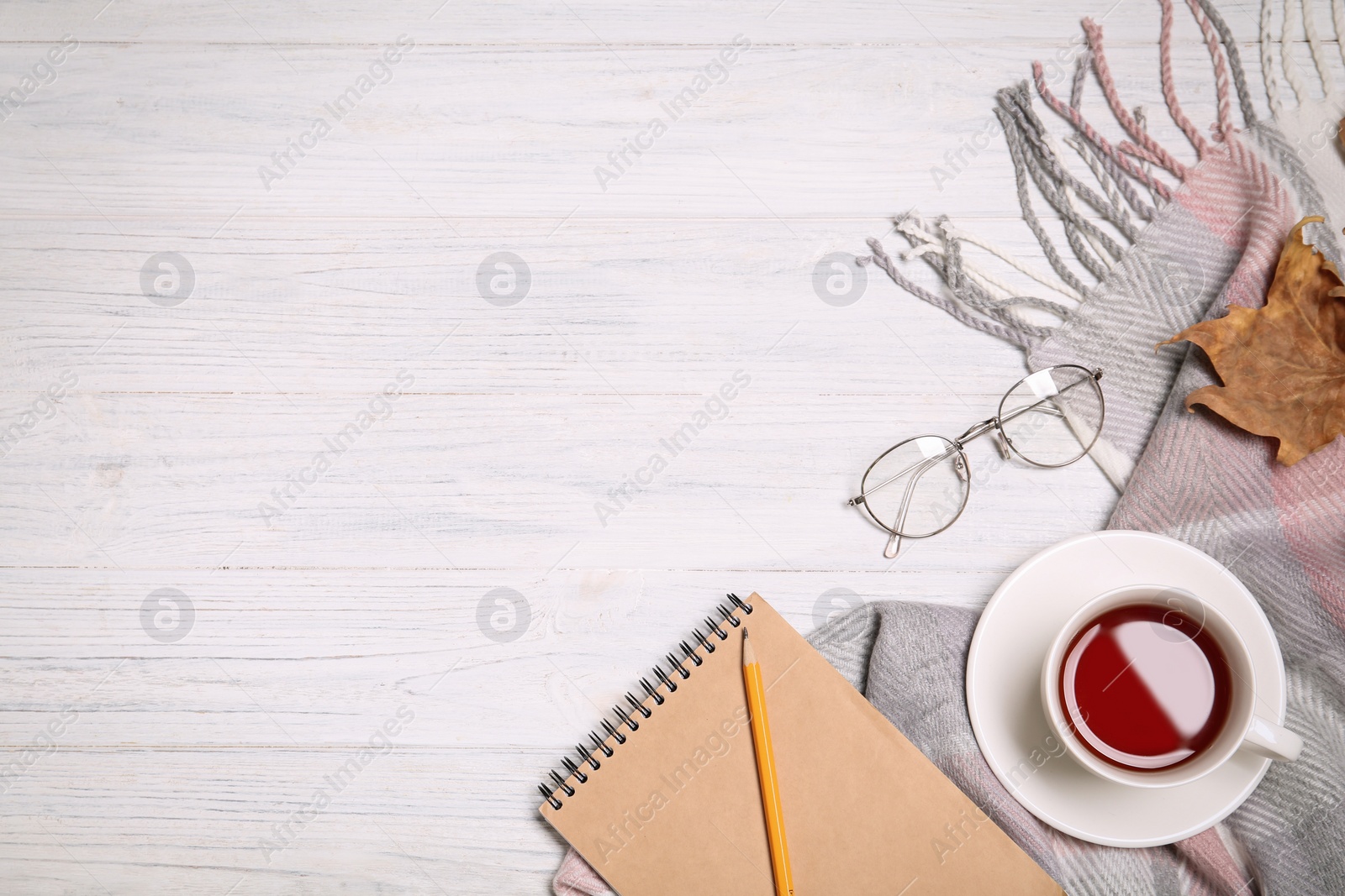 Photo of Flat lay composition with cup of hot tea and glasses on white wooden background. Space for text