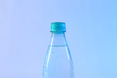 Photo of Plastic bottle of pure water on color background, closeup
