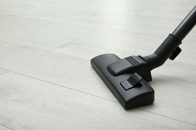Hoovering floor with modern vacuum cleaner. Space for text