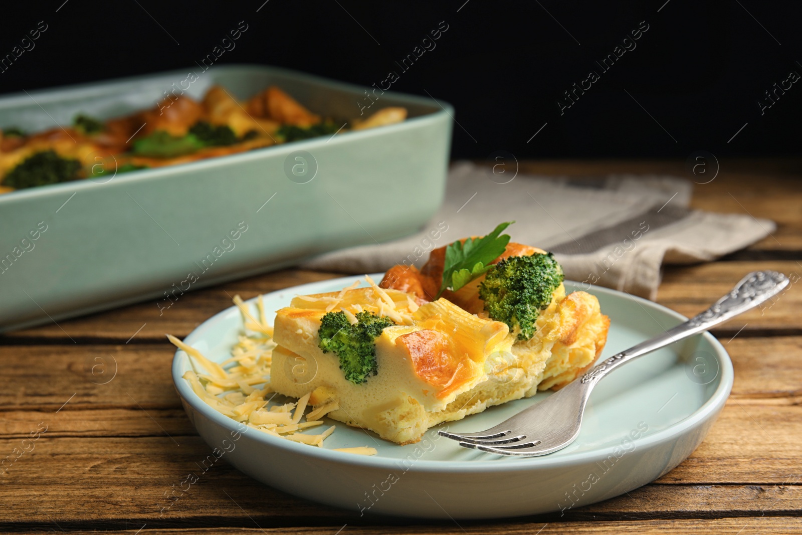 Photo of Tasty broccoli casserole served on wooden table