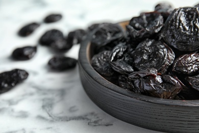 Photo of Plate of sweet dried plums on table, closeup with space for text. Healthy fruit