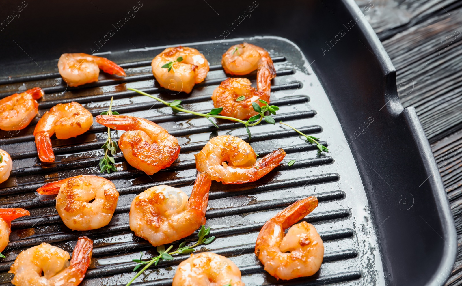 Photo of Delicious fried shrimps in grill pan, closeup