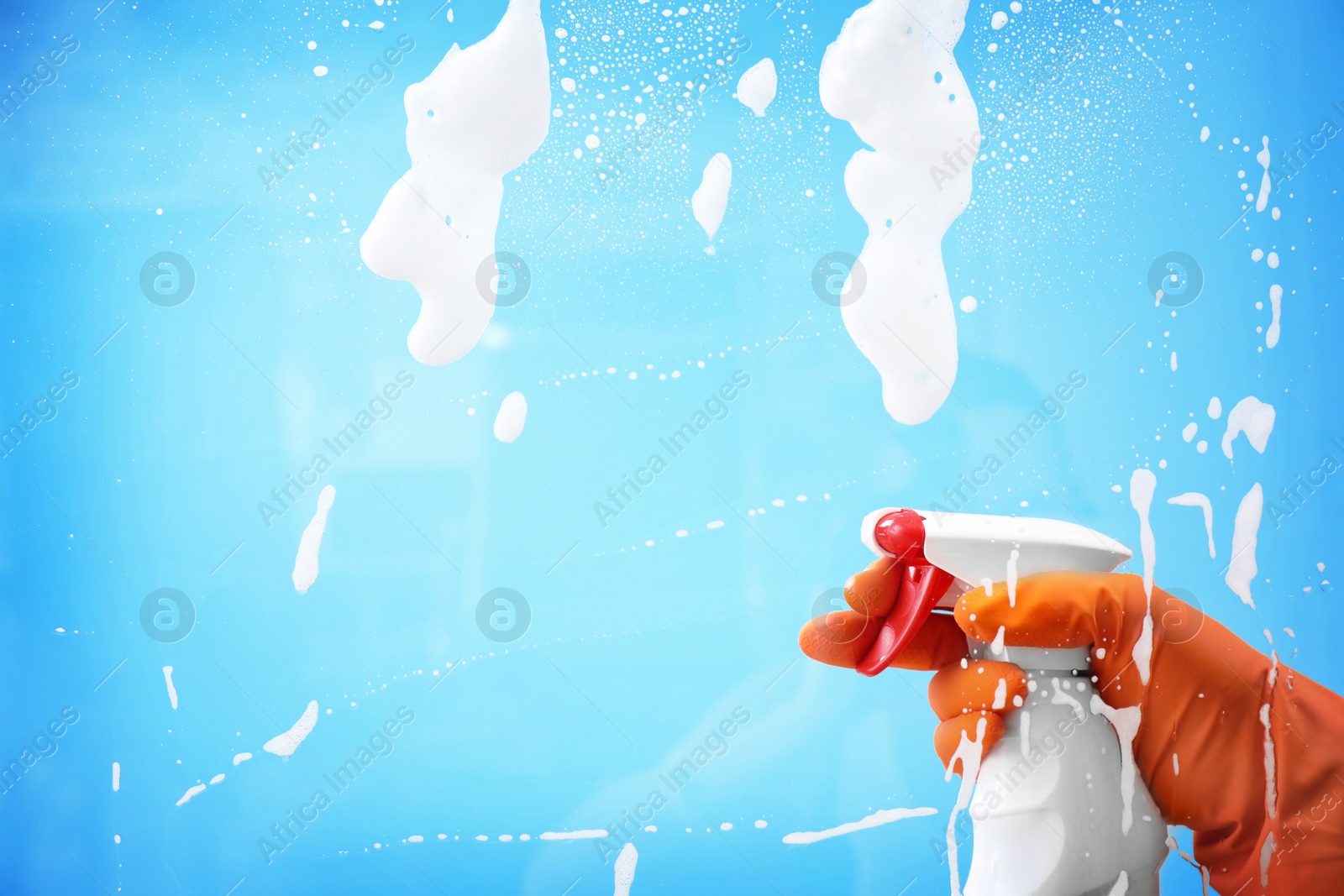 Photo of Woman cleaning glass against color background