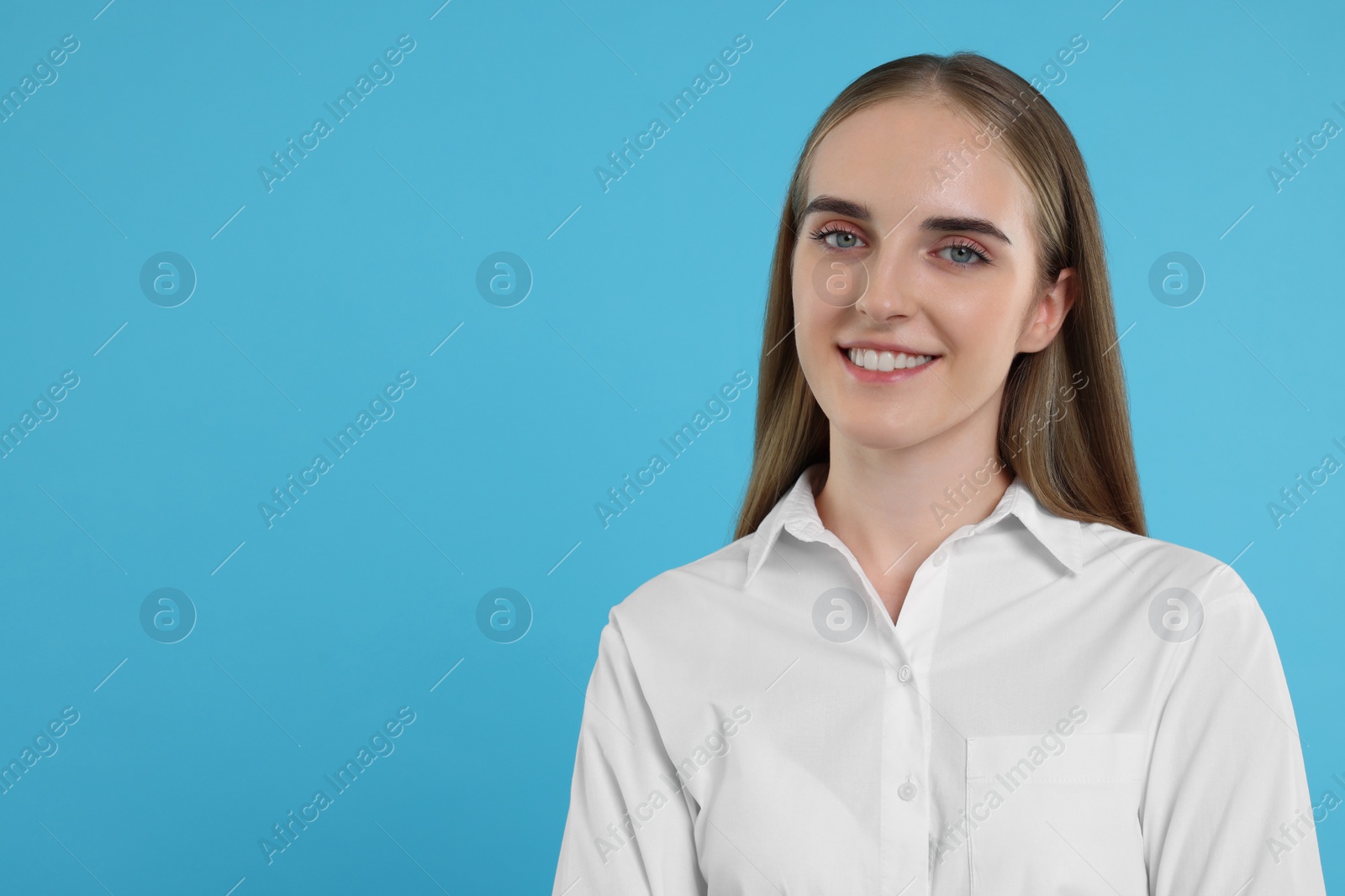 Photo of Portrait of happy young secretary on light blue background, space for text