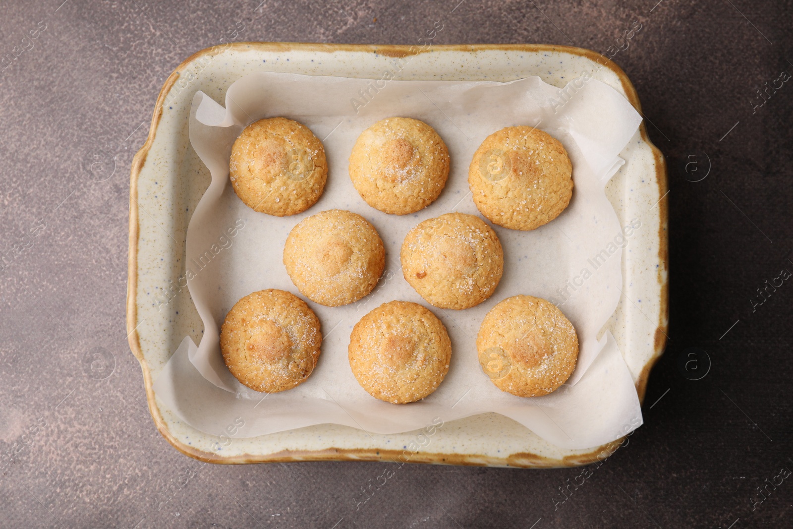 Photo of Tasty sweet sugar cookies in baking dish on brown table, top view