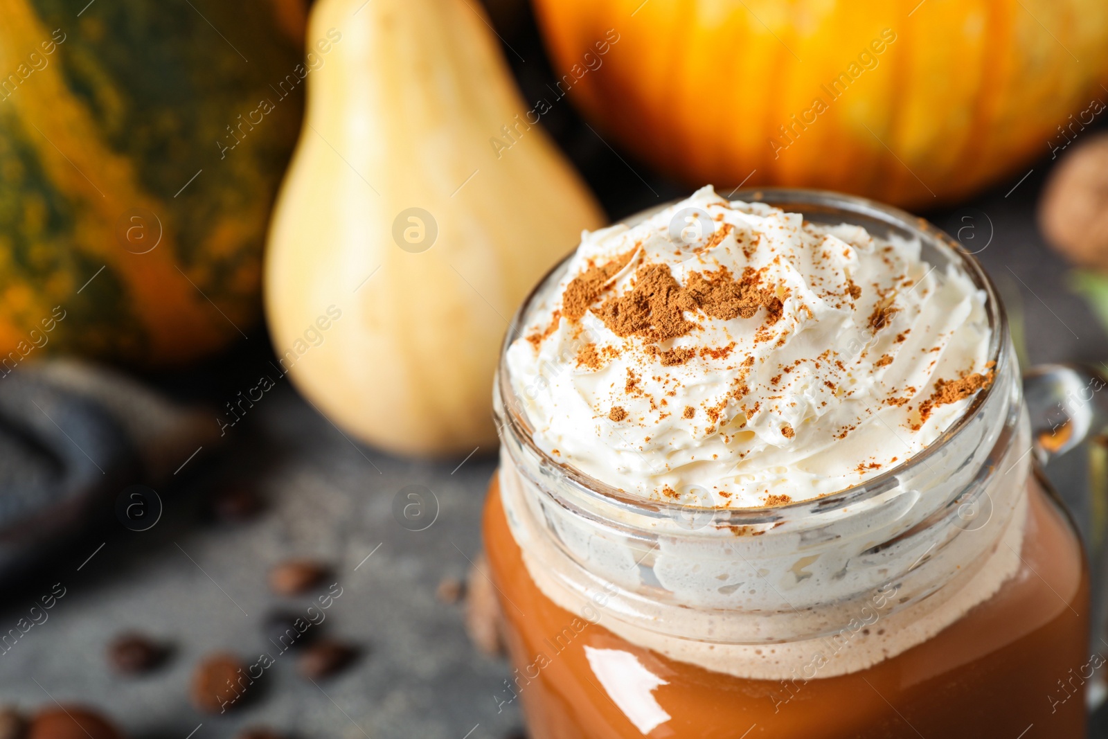 Photo of Mason jar with tasty pumpkin spice latte on grey table, closeup