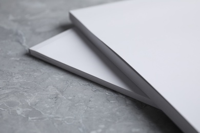 Photo of Blank books on light grey marble background, closeup. Mock up for design