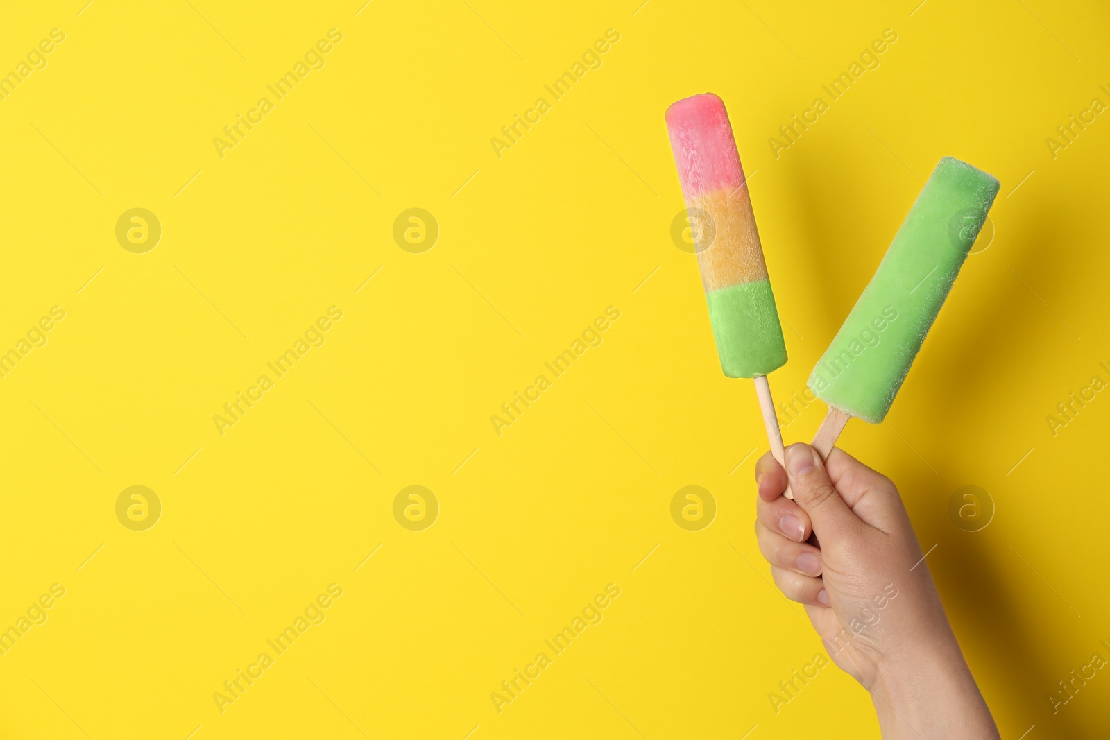 Photo of Woman holding delicious ice creams against color background, space for text