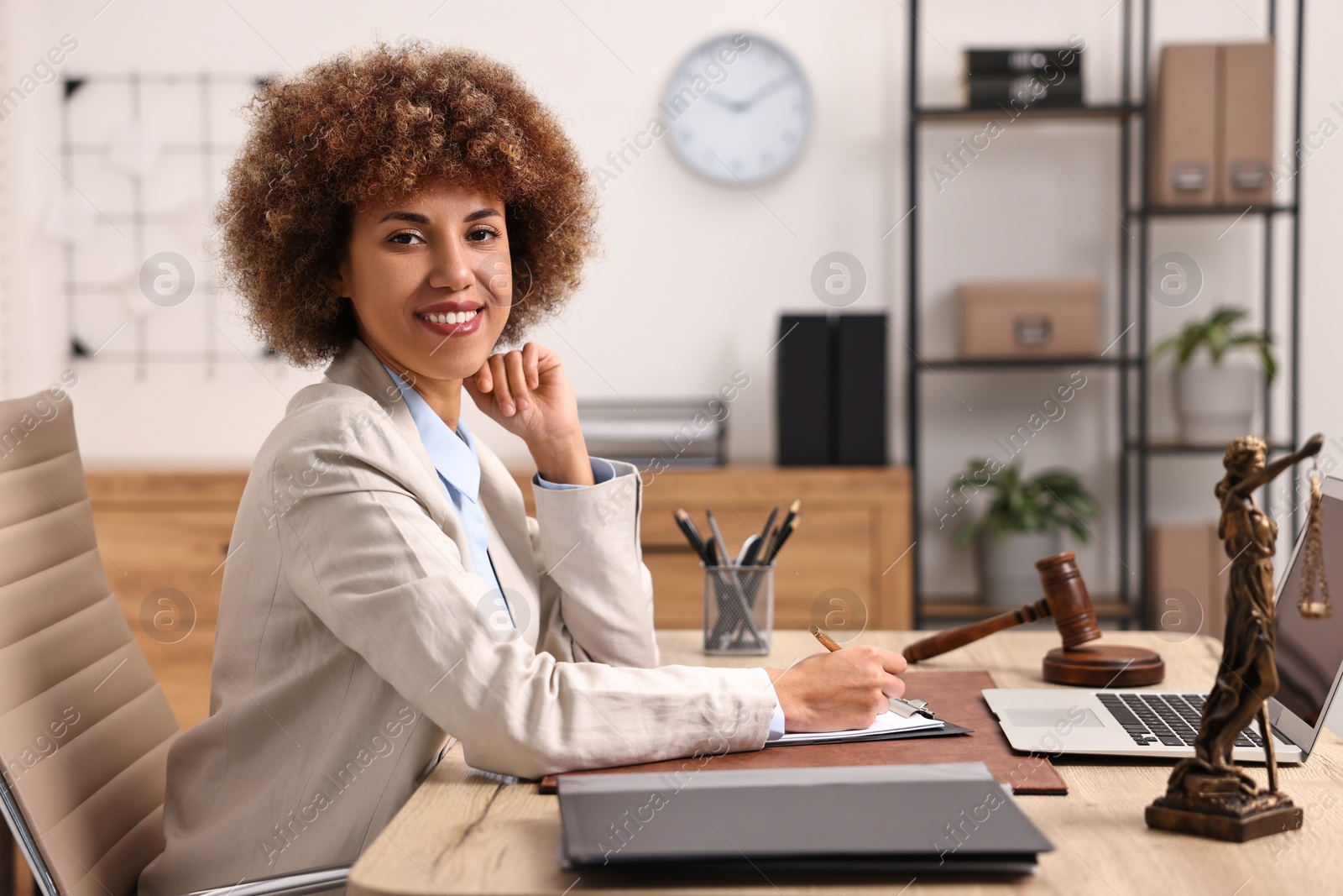 Photo of Notary with clipboard writing notes at workplace in office