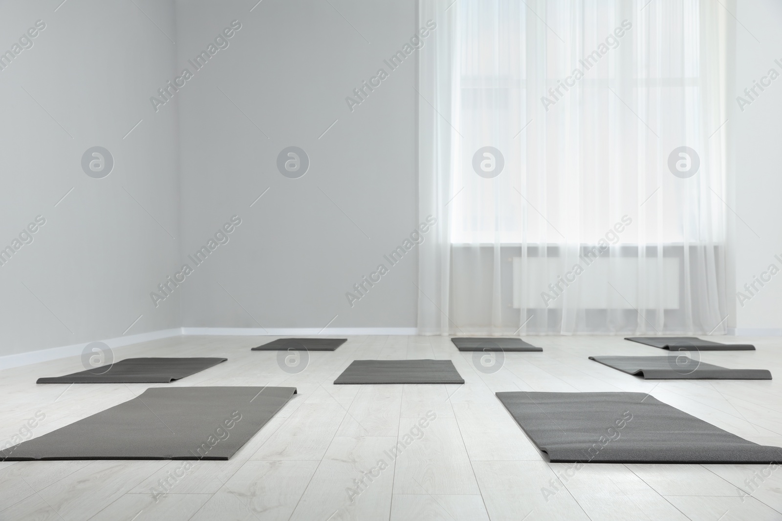 Photo of Spacious yoga studio with exercise mats. Space for text