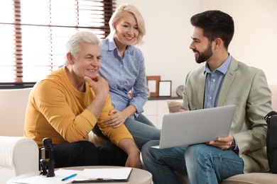 Photo of Male notary working with mature couple in office