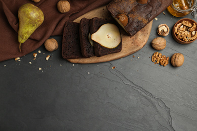 Flat lay composition with tasty pear bread on black table, space for text. Homemade cake