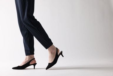 Photo of Businesswoman in black shoes on white background, closeup