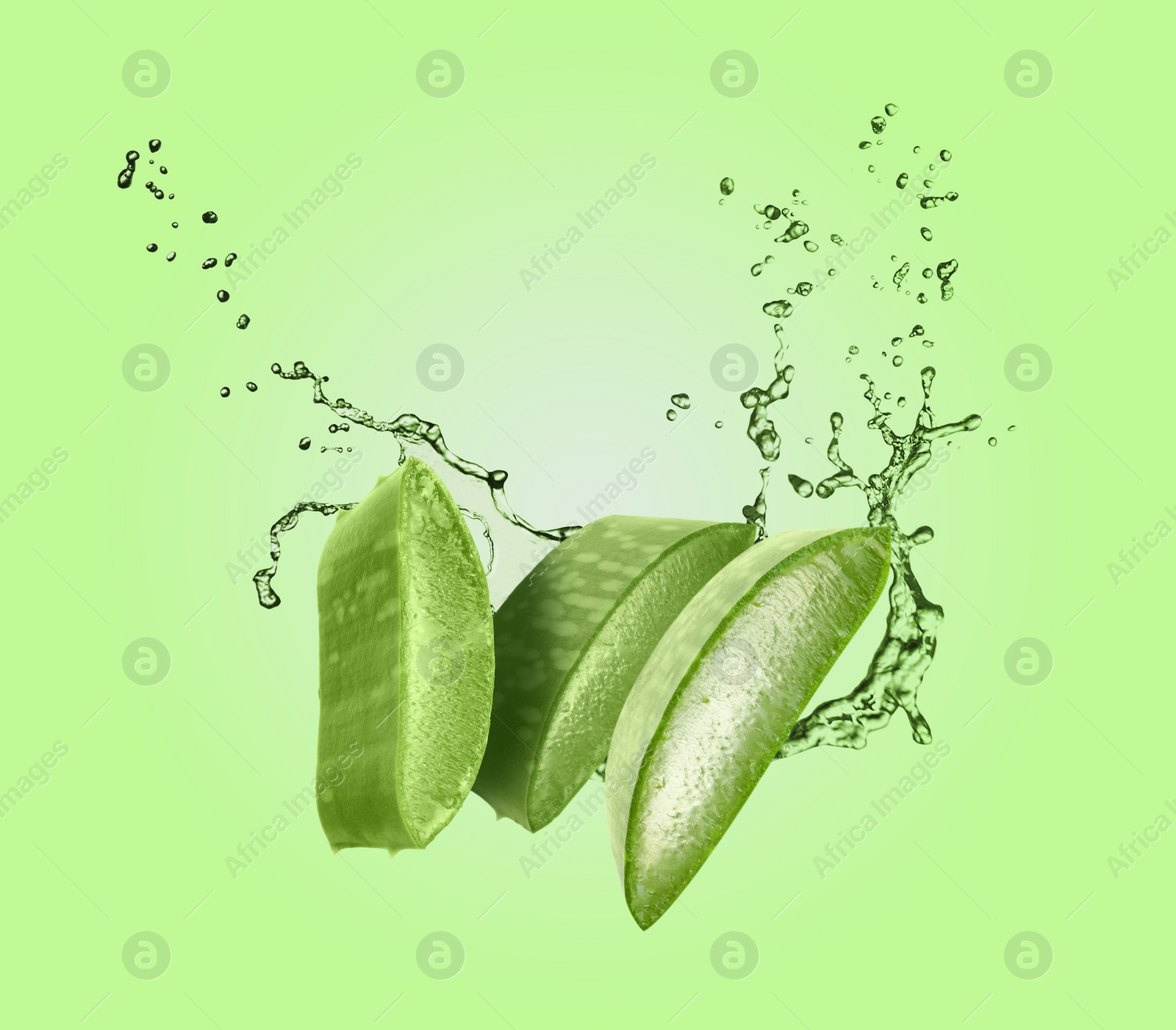 Image of Sliced aloe vera leaf and splashes of juice on green background