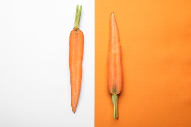 Flat lay composition with halves of fresh carrot on color background