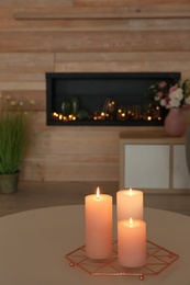 Photo of Burning candles on table in living room