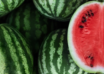 Photo of Delicious whole and cut watermelons as background, closeup