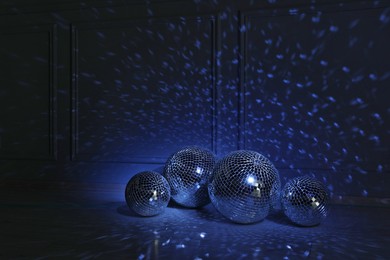 Shiny disco balls indoors, toned in dark blue