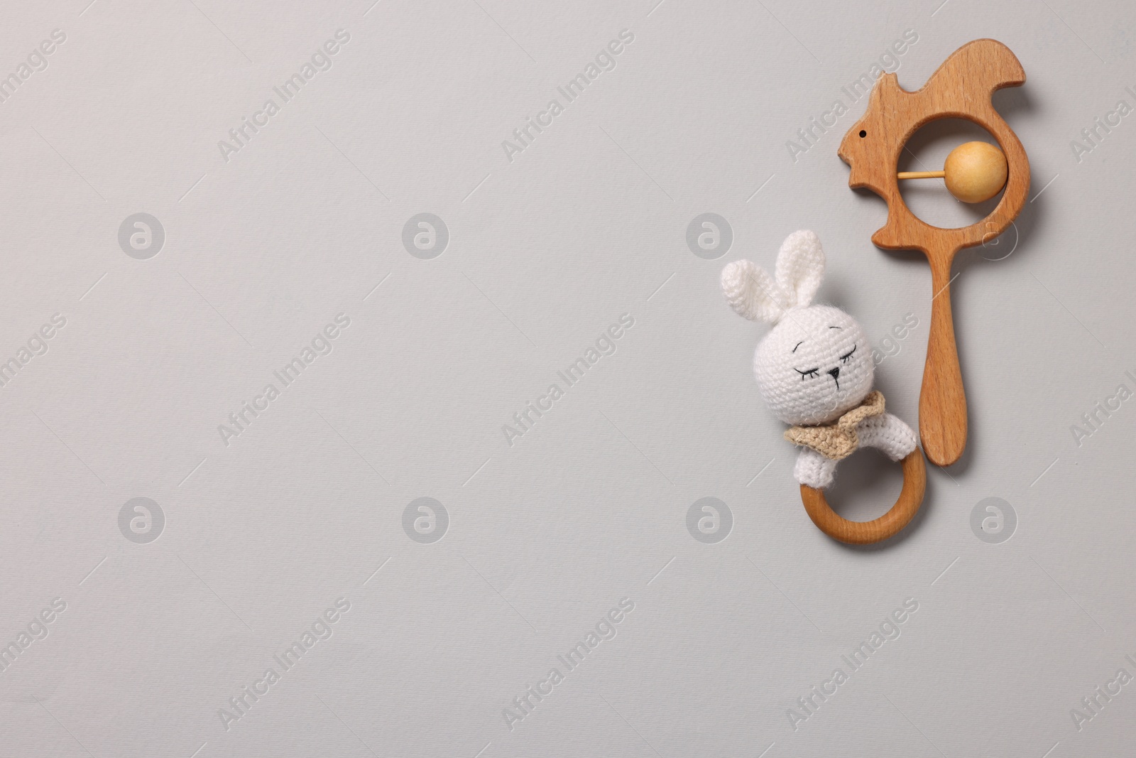 Photo of Baby accessories. Rattles on grey background, top view. Space for text