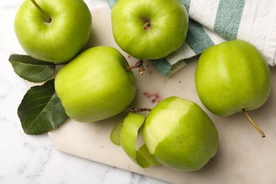 Photo of Ripe green apples and leaves on white marble table, flat lay