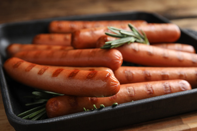Photo of Delicious grilled sausages with rosemary on table, closeup