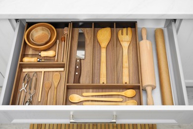 Photo of Open drawerkitchen cabinet with different utensils, above view