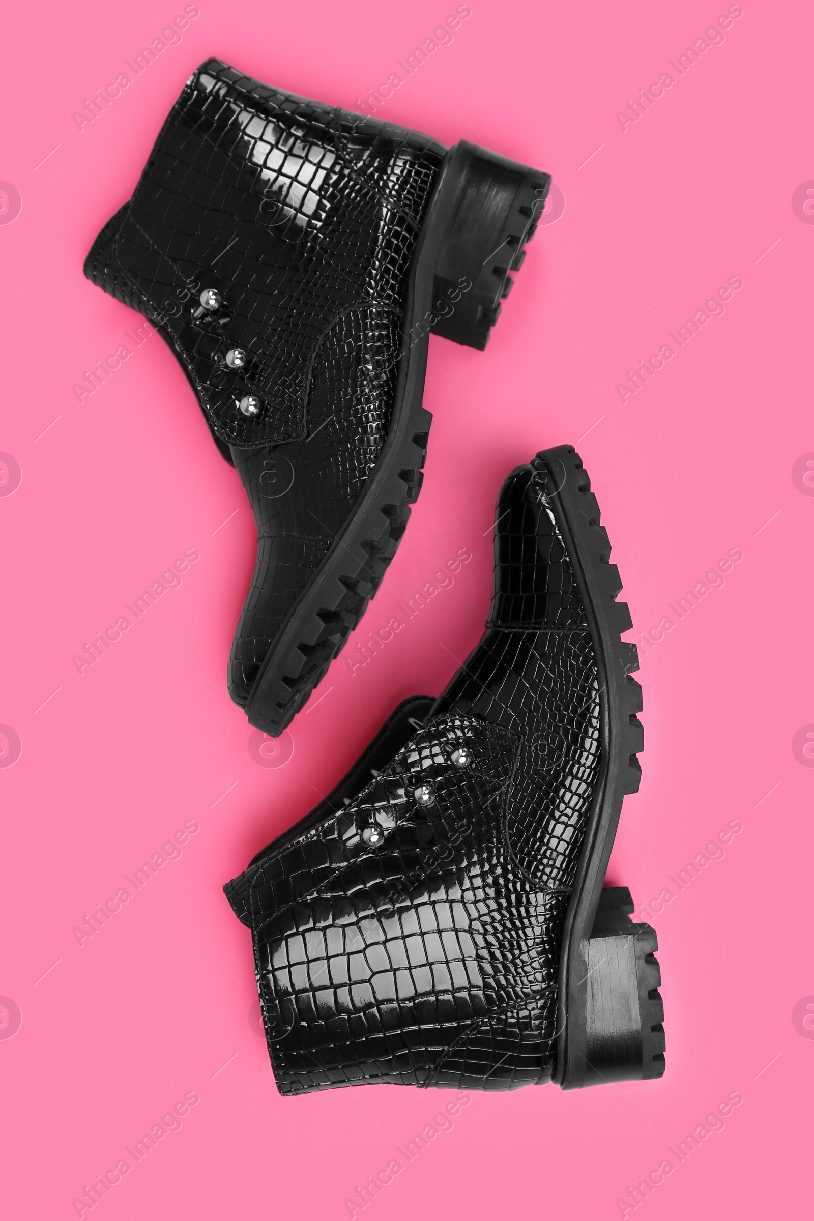 Photo of Pair of stylish ankle boots on pink background, top view