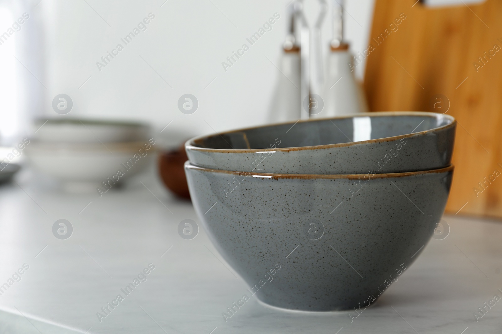 Photo of Beautiful ceramic bowls on white countertop in kitchen. Space for text