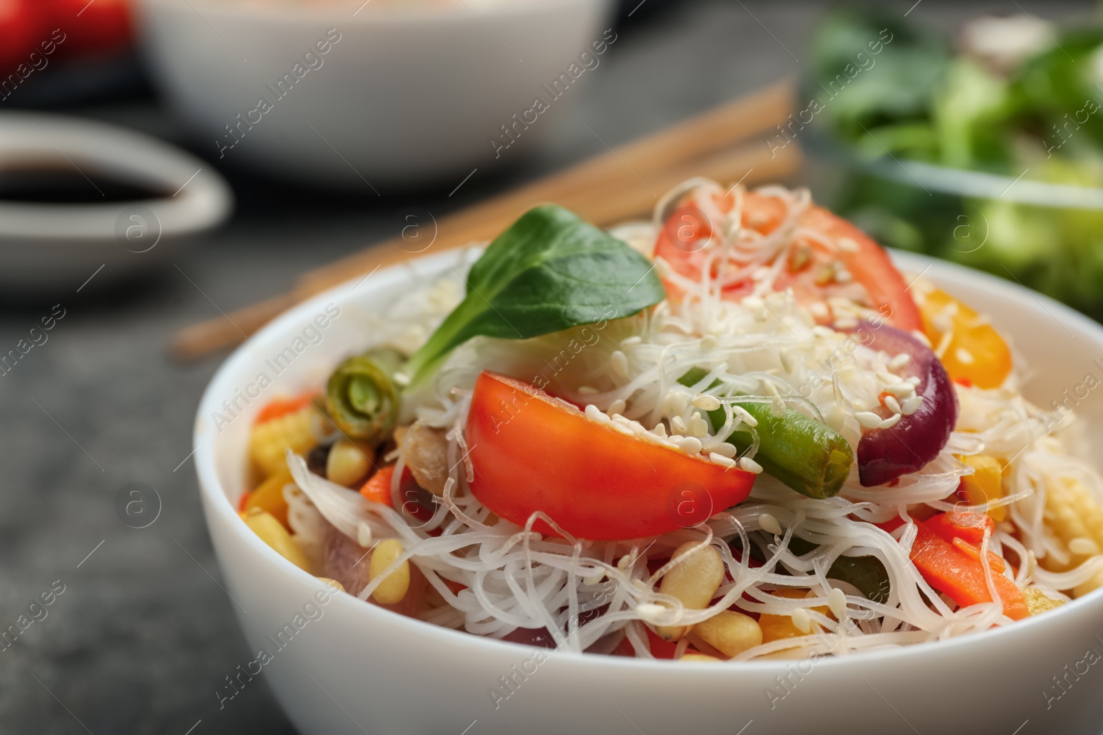 Photo of Tasty cooked rice noodles with vegetables on table, closeup