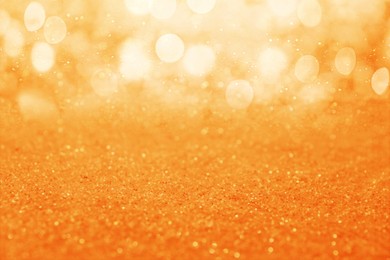Image of Shiny orange glitter and blurred lights on background. Bokeh effect