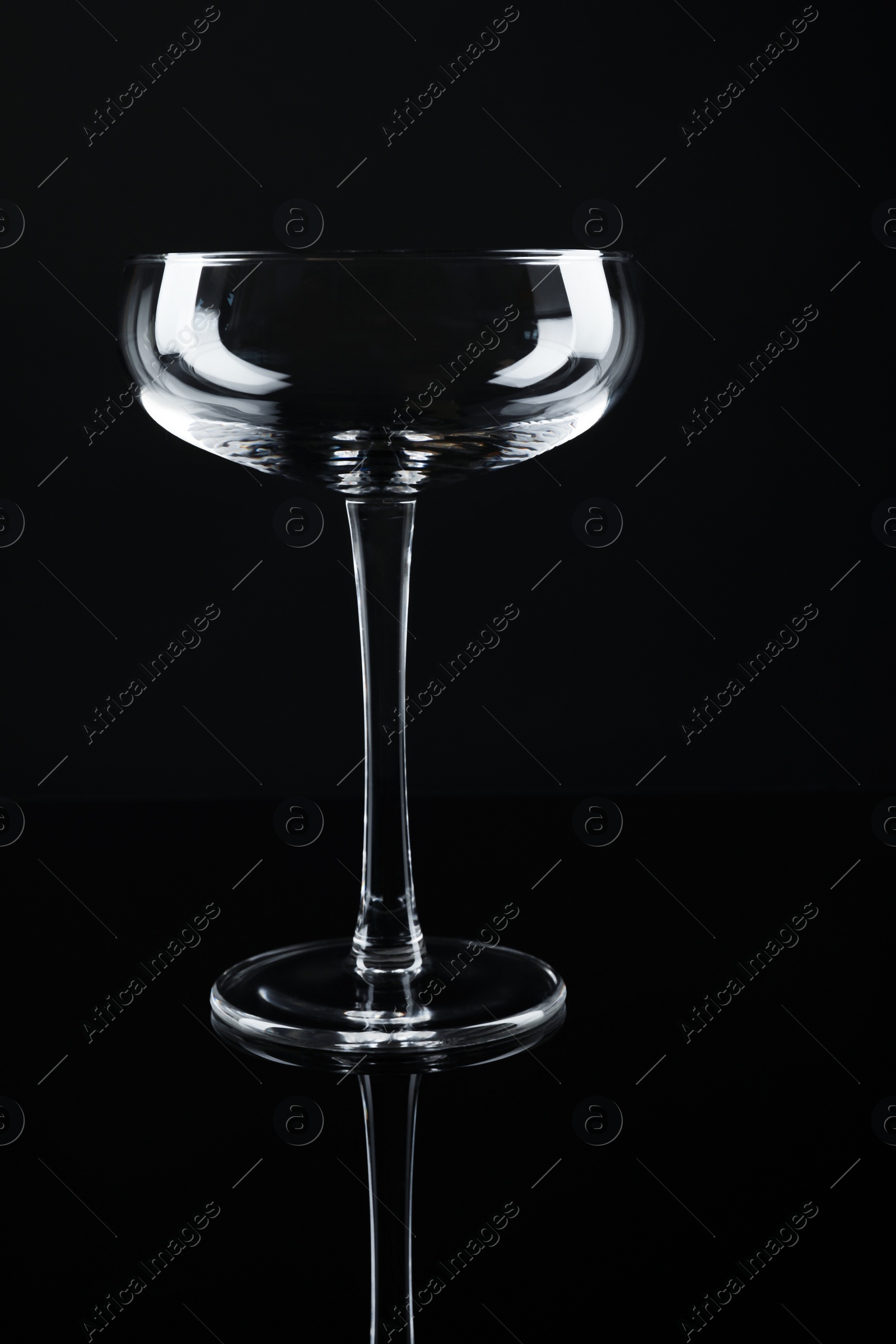 Photo of New empty champagne glass on black background