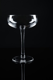 Photo of New empty champagne glass on black background