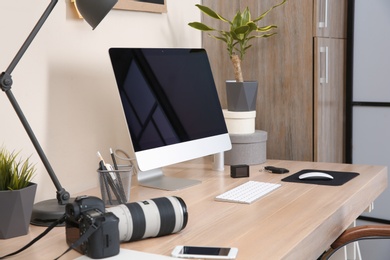 Photo of Interior of comfortable work place with computer on table at home