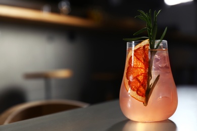 Photo of Glass of delicious cocktail with vodka on counter in bar. Space for text