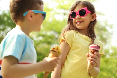 Photo of Cute little children with delicious ice creams outdoors