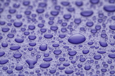 Water drops on lilac background, closeup view