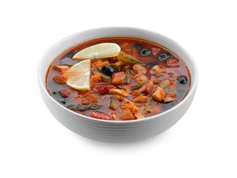 Meat solyanka soup with sausages, olives and vegetables in bowl isolated on white