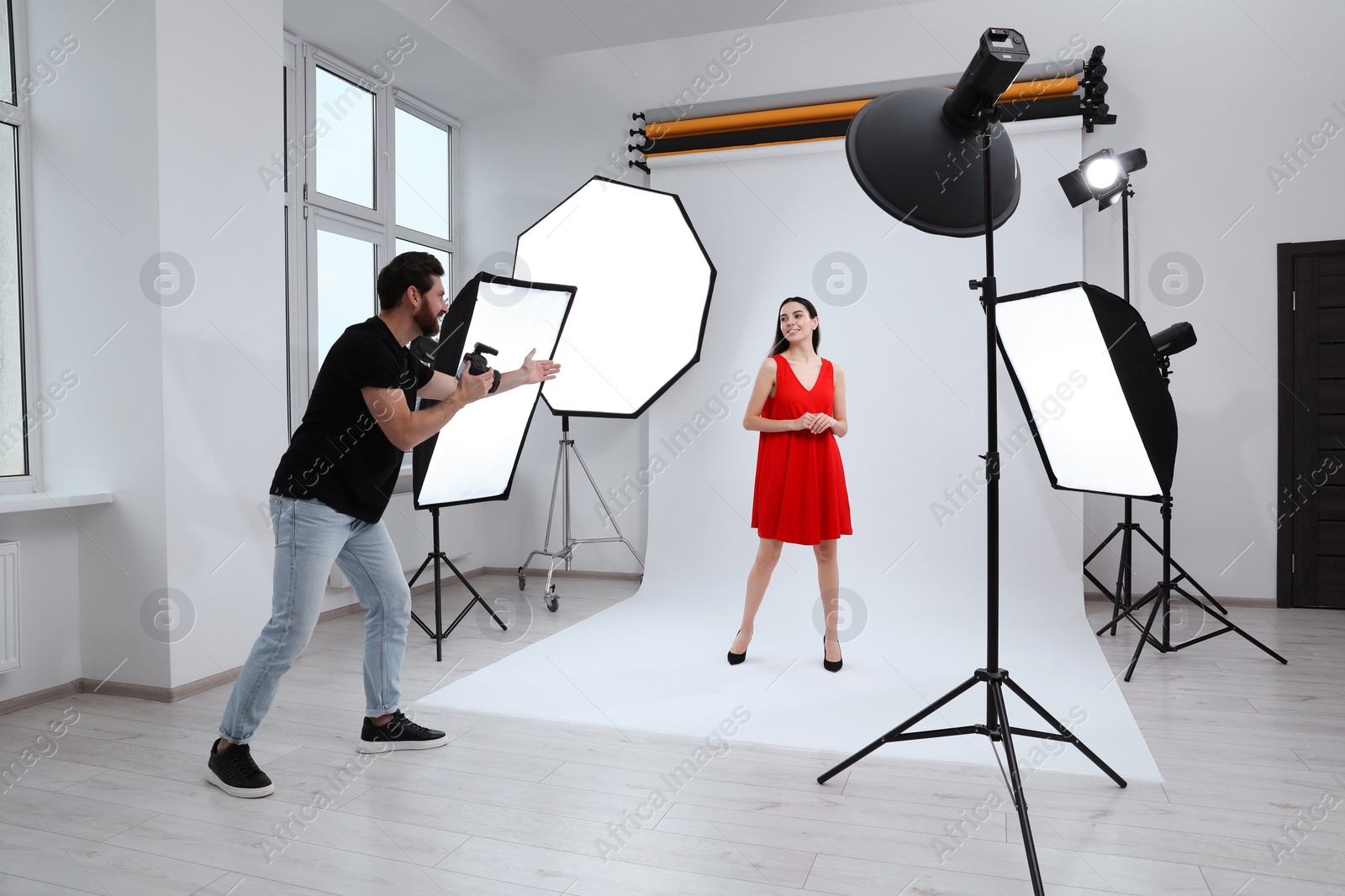 Photo of Beautiful young model posing for professional photographer in studio