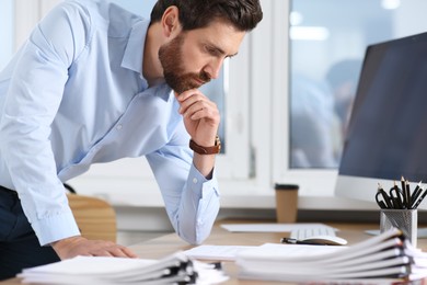 Businessman working with documents at wooden table in office